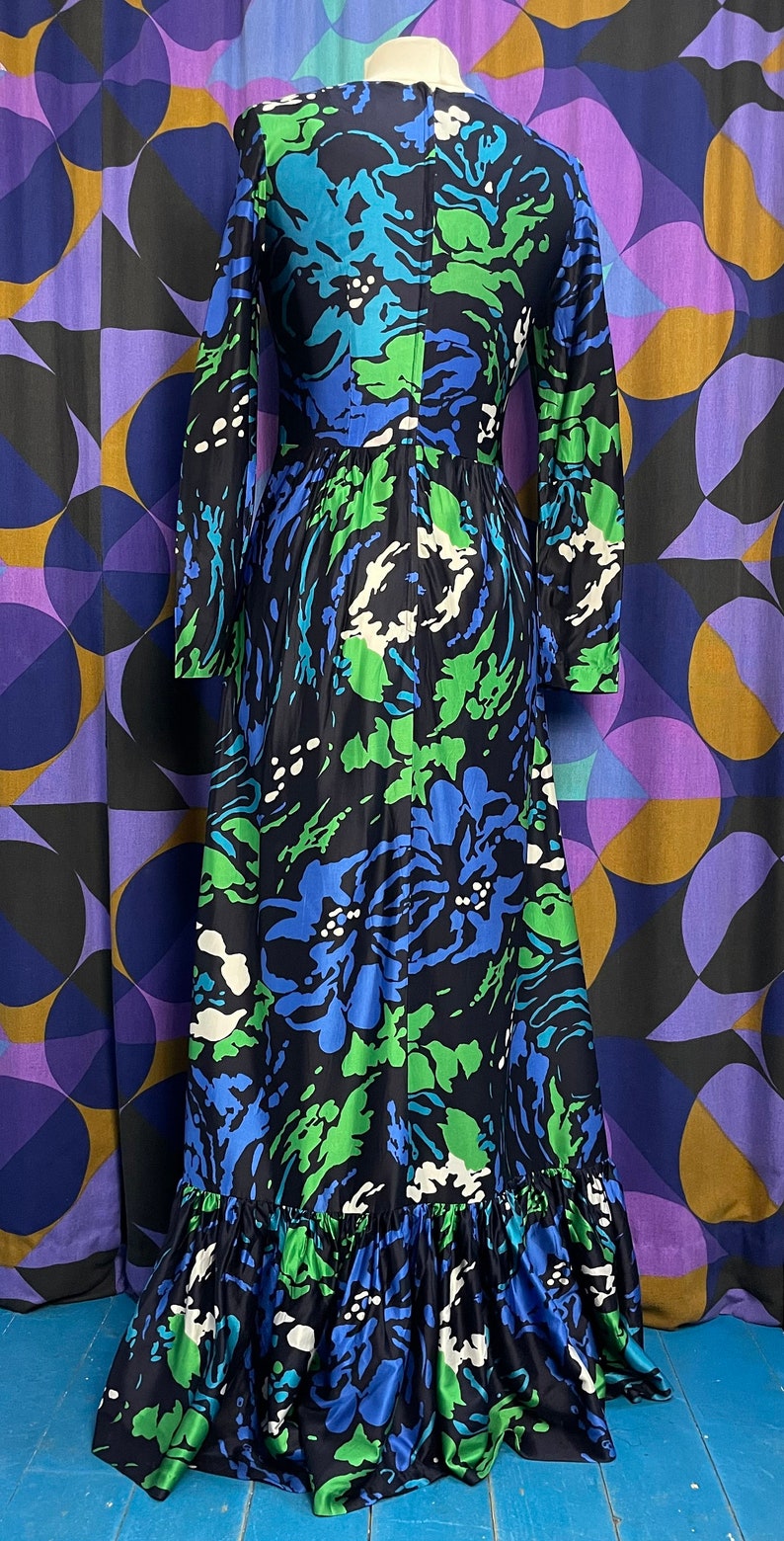 May include: A long-sleeved maxi dress with a floral print in shades of blue, green, and white. The dress has a ruffled hem and a fitted bodice.