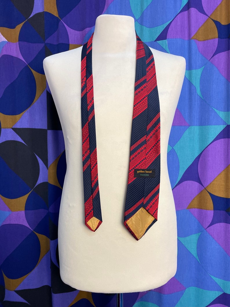 Cravate vintage des années 70, grande harpe en polyester à rayures diagonales rouges et bleu marine à motifs dorés par Golden Tassel image 2