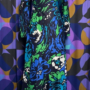May include: A long-sleeved maxi dress with a floral print in shades of blue, green, and white. The dress has a ruffled hem and a fitted bodice.