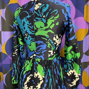 May include: A long-sleeved dress with a black background and a swirling abstract pattern in shades of blue, green, and white.