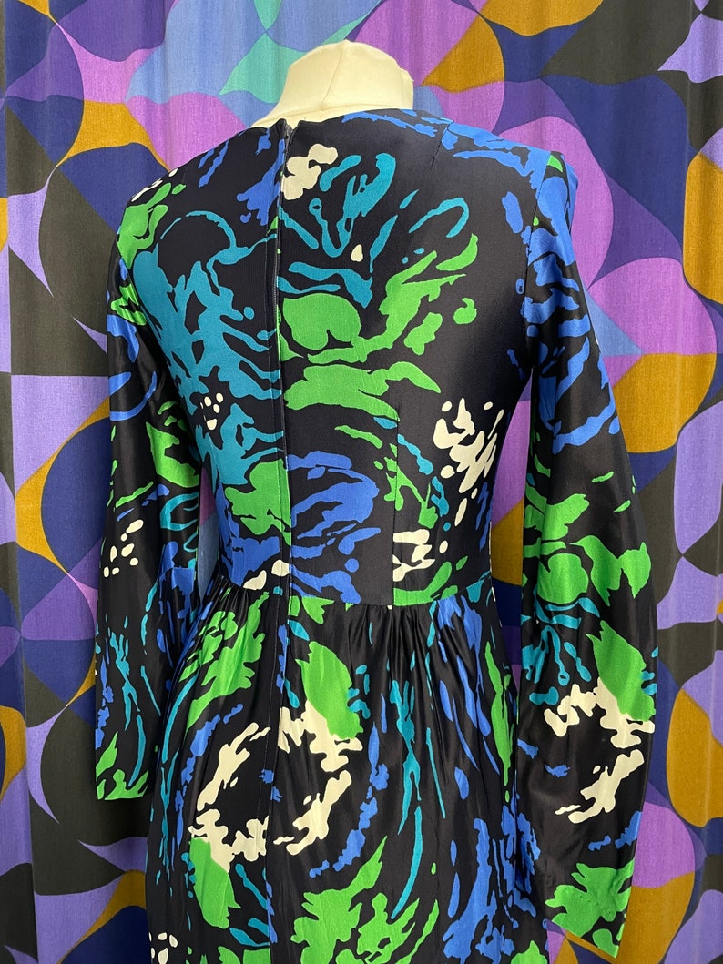 May include: A long-sleeved dress with a black background and a swirling abstract pattern in shades of blue, green, and white.