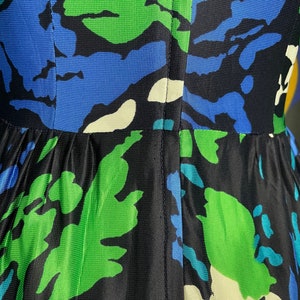 May include: A black, green, and blue patterned dress with a seam down the back.