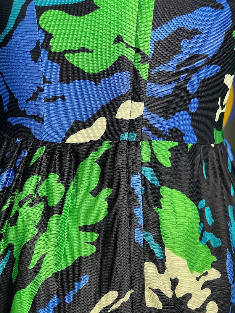 May include: A black, green, and blue patterned dress with a seam down the back.