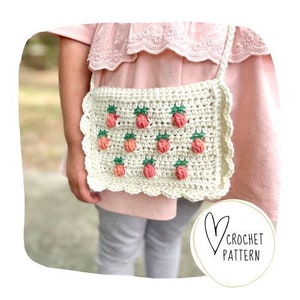 Könnte beinhalten: Eine cremefarbene Häkeltasche mit gewelltem Rand und Träger, verziert mit rosa, orangefarbenen und grünen Erdbeermotiven. Der Text "CROCHET PATTERN" befindet sich in einem Kreis. Die Tasche wird über der Schulter getragen.