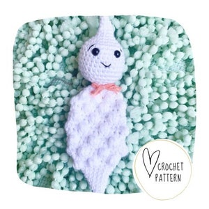 May include: A handmade white crochet ghost doll with a smiling face and a pink bow, set against a light green textured background. The doll has a teardrop-shaped head and a textured body. A circular logo with a heart and the words "CROCHET PATTERN" is in the lower right corner.