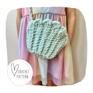May include: A light green, crocheted seashell-shaped purse with a strap. The purse is made of a textured yarn and has a scalloped edge. The words "CROCHET PATTERN" are in a circle with a heart.