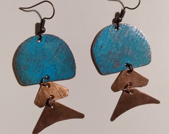 May include: A pair of dangle earrings with a turquoise blue, semi-circular top piece and three layered, triangular, copper-coloured pieces hanging below.
