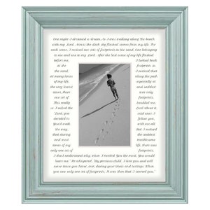 May include: A black and white photo of footprints in the sand on a beach. The photo is framed in a light blue frame. The text in the photo reads: "One night I dreamed a dream. I was walking along the beach with my Lord. Across the dark sky flashed scenes from my life. For each scene, I noticed two sets of footprints in the sand, one belonging to me and one to my Lord. After the last scene of my life flashed before me... I looked back at the sand. At many times of my life, the very saddest times, there was only one set of footprints. I asked the Lord, 'You deserted me, You didn't walk the way that during that most times of my only one set of... I don't understand why when I needed You the most, You would leave me.' He whispered, 'My precious child, I love you and will never leave you. Never, ever, during your trials and testings. When you saw only one set of footprints, It was then that I carried you.'"