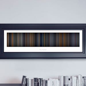 May include: A framed black and white minimalist movie poster with a colorful bar code design. The title "The Matrix" is printed below the barcode.