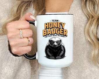 May include: A white ceramic mug with a black handle and the text "But First, Coffee" in a black, bold font. The mug is on a white surface. The mug is approximately 4 inches tall.