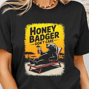 Puede incluir: Taza de cerámica blanca con asa negra y la frase "But First, Coffee" en negro. La taza se muestra sobre un fondo borroso, sugiriendo un ambiente acogedor.