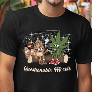 May include: Black t-shirt with a graphic of a cartoon mushroom and a marijuana plant smoking a joint. The text "Questionable Morels" is printed below the graphic.