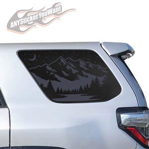 May include: A black mountain and forest scene window decal applied to the rear window of a silver vehicle. The decal features a crescent moon, stars, and the text "ANYSticker YouWant".