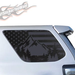 May include: A black and gray mountain and forest scene is depicted on a vehicle window. The design incorporates the American flag with stars and stripes, and the text "ANYStickerYouWant" is visible.