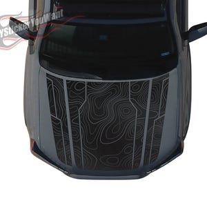 May include: A top-down view of a dark gray car hood with a topographic map design in white. The hood features a series of vertical panels with the map pattern. The text "ANYSticker YouWant" is visible in the upper left corner.
