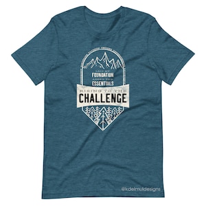 K&ouml;nnte beinhalten: Tealblaues T-Shirt mit einem wei&szlig;en Grafikdesign einer Bergkette mit dem Text "Laid my foundation, added the essentials, Rising to the challenge".
