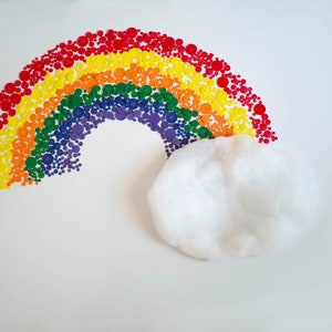 Puede incluir: Un arcoíris hecho de botones coloridos con una nube blanca debajo.