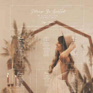 Puede incluir: Un plano de asientos de boda con un tema rústico. El plano está hecho de acrílico transparente y cuelga de un marco de madera. Los nombres de los invitados están listados en cada tarjeta, junto con el número de mesa. El plano está decorado con vegetación y flores.