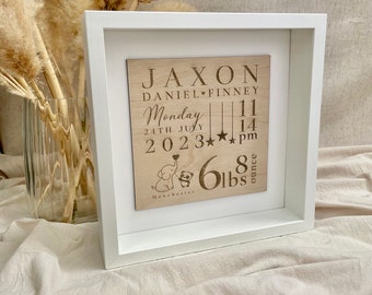 May include: A wooden plaque with a white frame, announcing the birth of Jaxon Daniel Finney. The plaque includes the date and time of birth, weight, and location. The plaque features a small illustration of a dog and a panda.