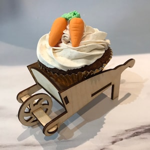 Wooden, 3D wheelbarrow used as a cupcake holders for party decorations holding a chocolate cupcake