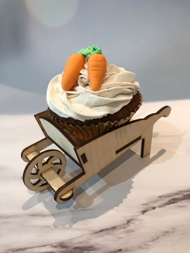 Wooden, 3D wheelbarrow used as a cupcake holders for party decorations holding a chocolate cupcake