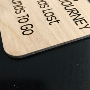 May include: A wooden sign with the text "JOURNEY", "IDS LOST", and "UNDS TO GO" engraved on it.