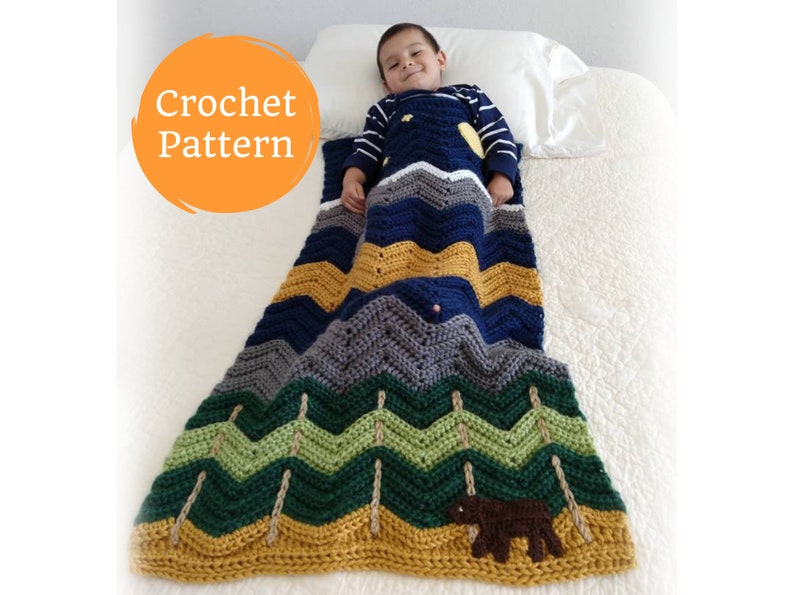 May include: Crochet pattern for a colorful chevron blanket with a bear applique. The blanket is made with blue, green, yellow, and gray yarn. The bear is brown and is sitting on the bottom of the blanket.