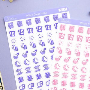 Puede incluir: Dos hojas de pegatinas con iconos de temática de bruja en morado y rosa. Las pegatinas presentan iconos como lunas, estrellas, calderos y libros. Las pegatinas están sobre un fondo morado con cartas de tarot, cristales y otra decoración de bruja.