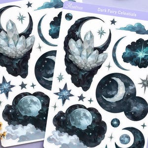 以下が含まれることがあります： ラベンダー色の表面に、天体テーマのステッカー、タロットカード、クリスタル、装飾要素が並んでいます。ステッカーには月、星、結晶の形が描かれています。ろうそく、月、太陽が神秘的なテーマを加えています。