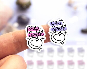 Könnte beinhalten: Zwei weiße Aufkleber mit einem Halbmond- und Sternenmotiv. Die Aufkleber haben einen Farbverlauf von Pink und Lila. Der Text auf den Aufklebern lautet "Prep Spell" und "Cast Spell".