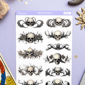May include: A sheet of skull divider stickers with a white background and black and gray skulls with intricate floral designs. The sheet is labeled "Skull Dividers" and "PS311".