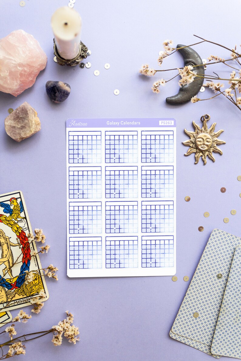 Op de afbeelding: Een vel met galaxy-kalender stickers met een blauw en wit verloop. De stickers zijn gerangschikt in een raster van 12, waarbij elke sticker een andere kalendermaand voorstelt. De stickers zijn gelabeld met "Galaxy Calendars" en "PS263".