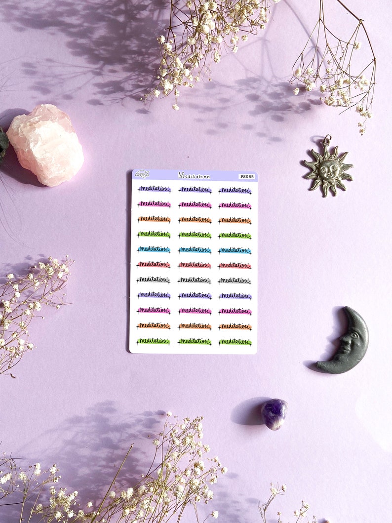 May include: A sheet of colorful stickers with the word "meditation" written in different colors and styles. The stickers are arranged in rows of three. There are also stickers of a sun and a moon.