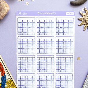 Op de afbeelding: Een vel met galaxy-thema kalender stickers met een blauwe en witte gradi&euml;nt achtergrond. De stickers zijn gelabeld "Galaxy Calendars" en "PS263".