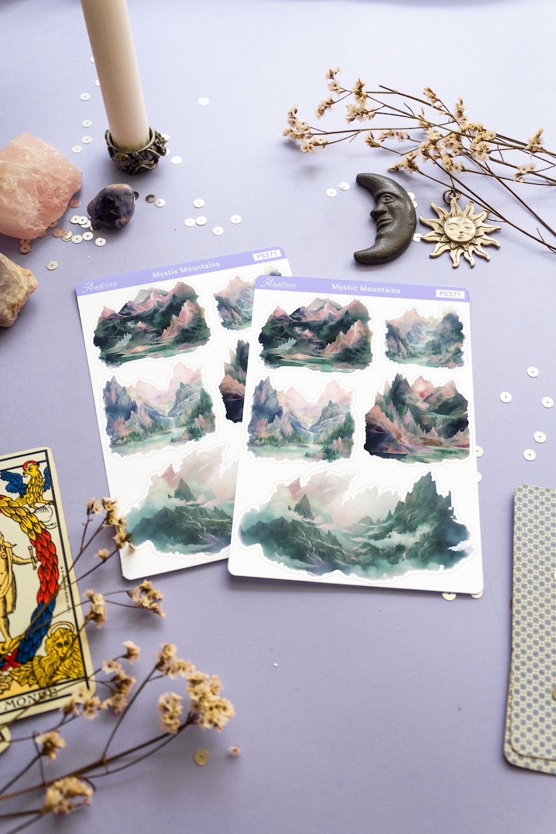 May include: Two sheets of stickers featuring watercolor illustrations of misty mountains. Each sheet has six stickers with different mountain scenes. The stickers are labeled "Mystic Mountains" and "Aestrive".