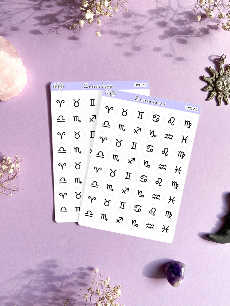 May include: Two sheets of white sticker paper with black zodiac symbols printed on them. The stickers are in a circle shape and are arranged in rows. The text "Zodiac Icons" is printed on the top of each sheet.