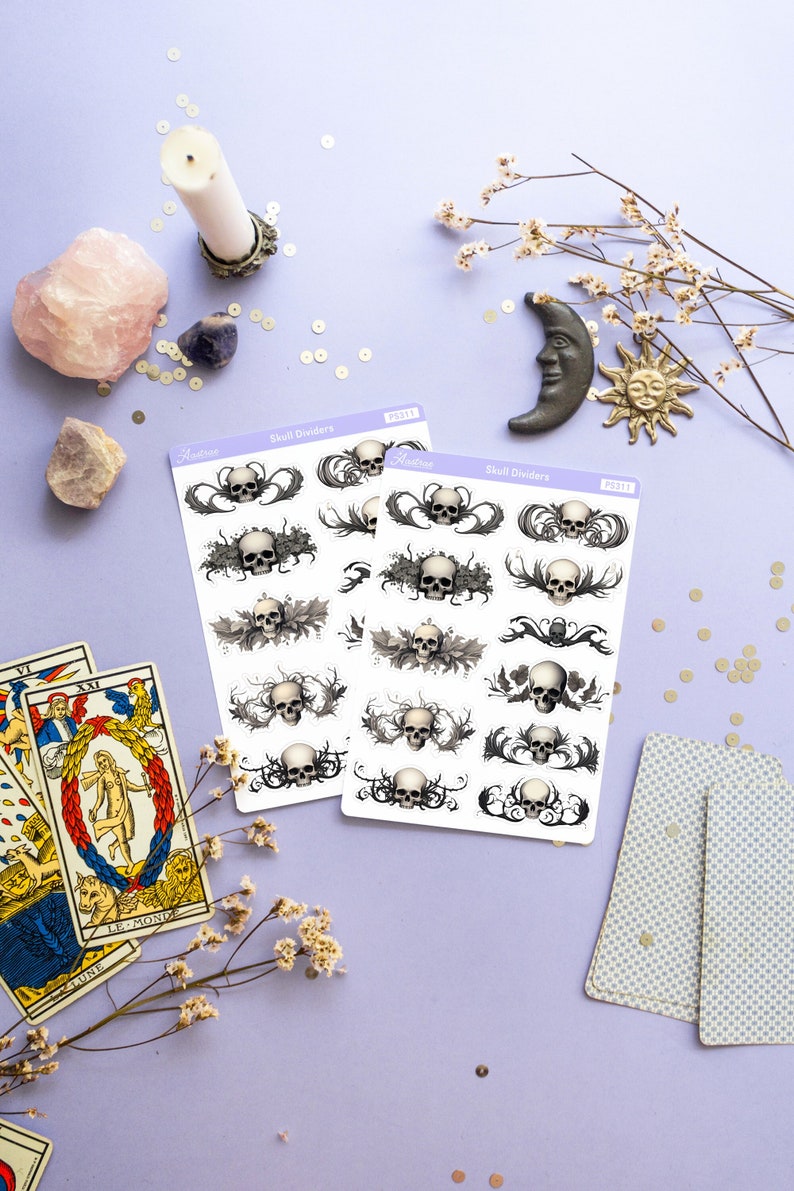 May include: Two sheets of skull divider stickers with a white background and black and white skull designs. The stickers are labeled "Skull Dividers" and have the text "Aesthetic" on them.