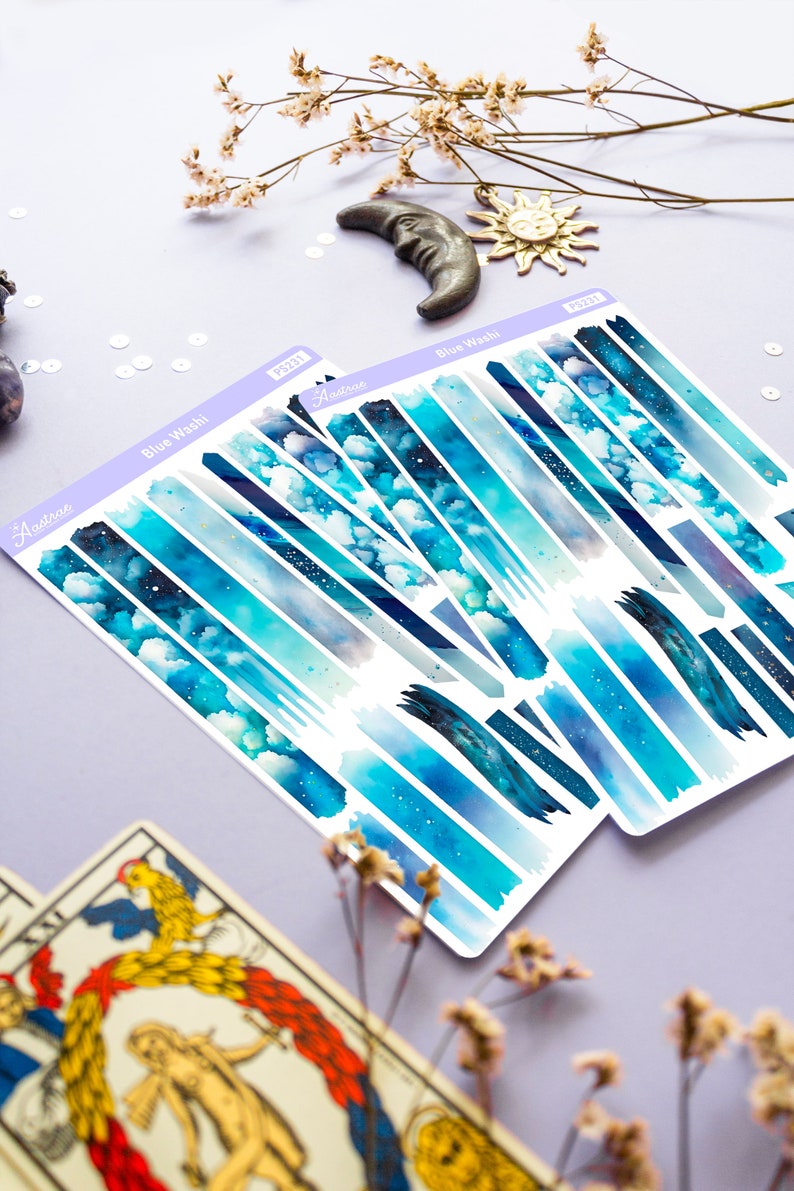 May include: Two sheets of blue watercolor washi tape with a starry sky and cloud design. The washi tape is labeled "Blue Wash" and "Audtree".