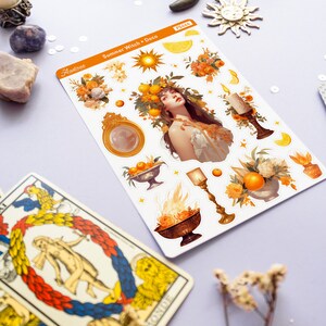 May include: A sheet of stickers featuring a summer witch theme. The stickers include a woman with a crown of oranges, a sun, a moon, candles, and flowers. The text on the sheet reads "Summer Witch Deco".
