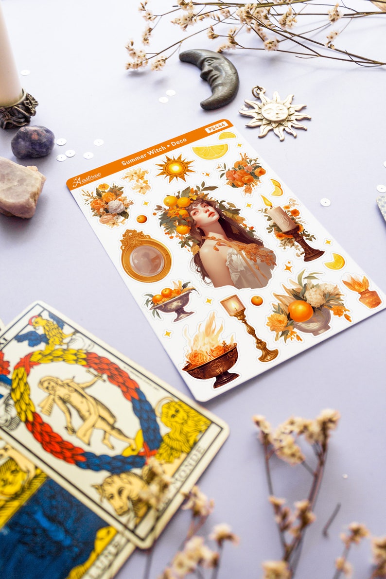 May include: A sheet of stickers featuring a summer witch theme. The stickers include a woman with a crown of oranges, a sun, a moon, candles, and flowers. The text on the sheet reads "Summer Witch Deco".