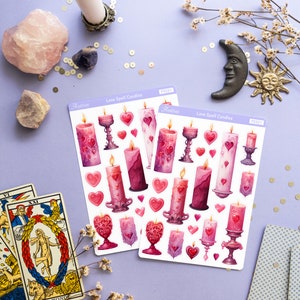 Pode incluir: Duas folhas de adesivos com ilustra&ccedil;&otilde;es de velas m&aacute;gicas de amor rosa e roxas com cora&ccedil;&otilde;es e casti&ccedil;ais. Os adesivos s&atilde;o etiquetados como "Love Spell Candles" e "Astrae" com o n&uacute;mero do produto "PS321".