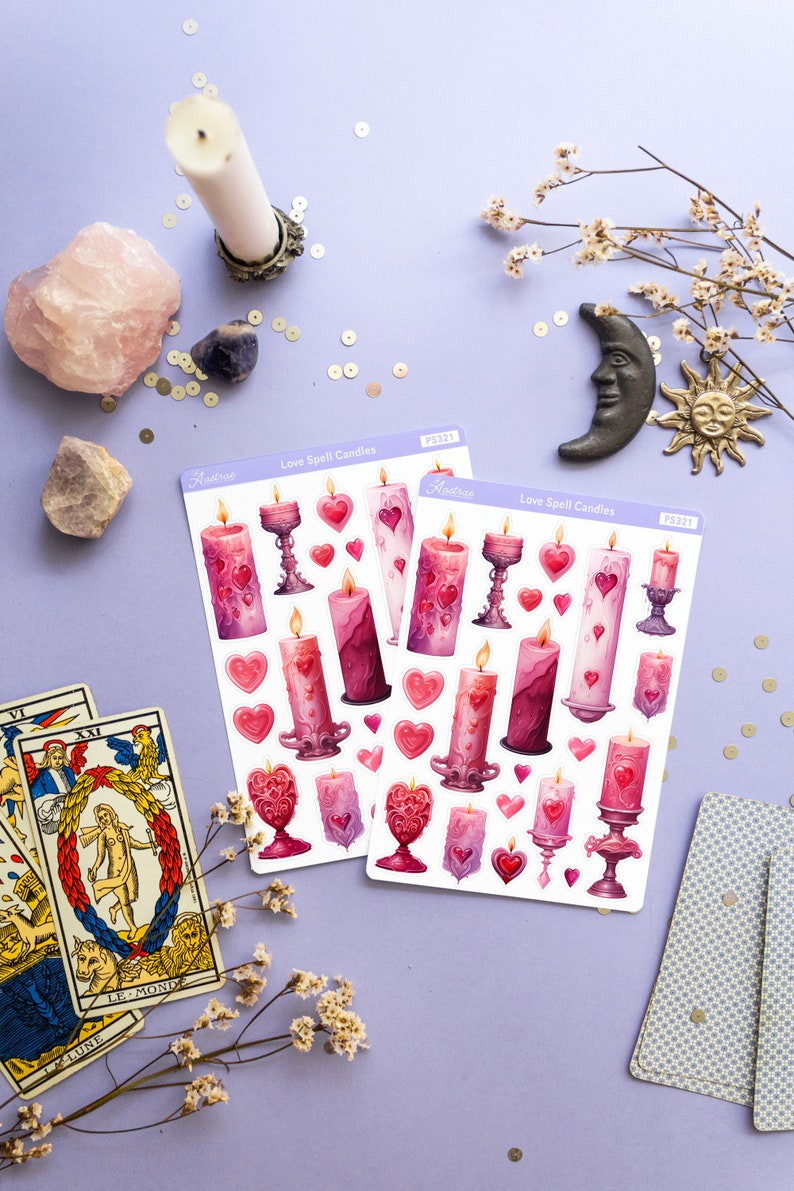 Pode incluir: Duas folhas de adesivos com ilustra&ccedil;&otilde;es de velas m&aacute;gicas de amor rosa e roxas com cora&ccedil;&otilde;es e casti&ccedil;ais. Os adesivos s&atilde;o etiquetados como "Love Spell Candles" e "Astrae" com o n&uacute;mero do produto "PS321".