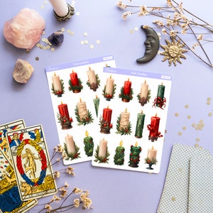 May include: Two sheets of stickers featuring illustrations of Yule candles. The stickers are on a purple background with gold glitter, tarot cards, and a white candle in a silver holder. The stickers are labeled "Yule Candles" and have the product number "PS315".