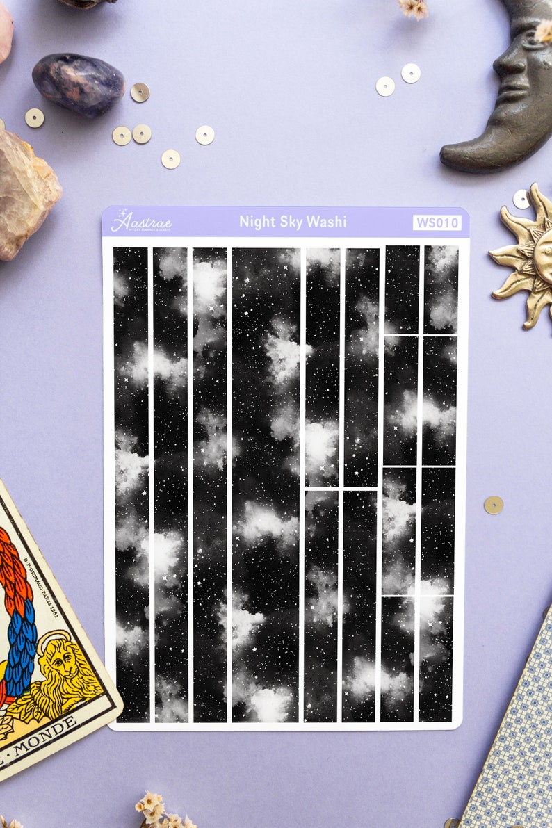 May include: A sheet of black and white washi tape with a night sky pattern. The tape is divided into 12 strips, each with a different section of the night sky. The washi tape is labeled "Night Sky Washi" and "WS010".
