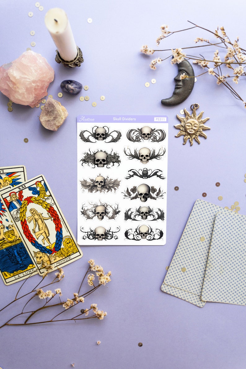 May include: A sheet of skull divider stickers with a white background and black and gray skull designs. The stickers are labeled "Skull Dividers" and "PS311".