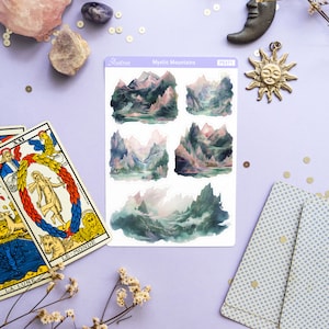 May include: A sheet of stickers featuring five watercolor illustrations of misty mountains. The stickers are on a white background and have a glossy finish. The sheet is labeled "Mystic Mountains" and "PS371".