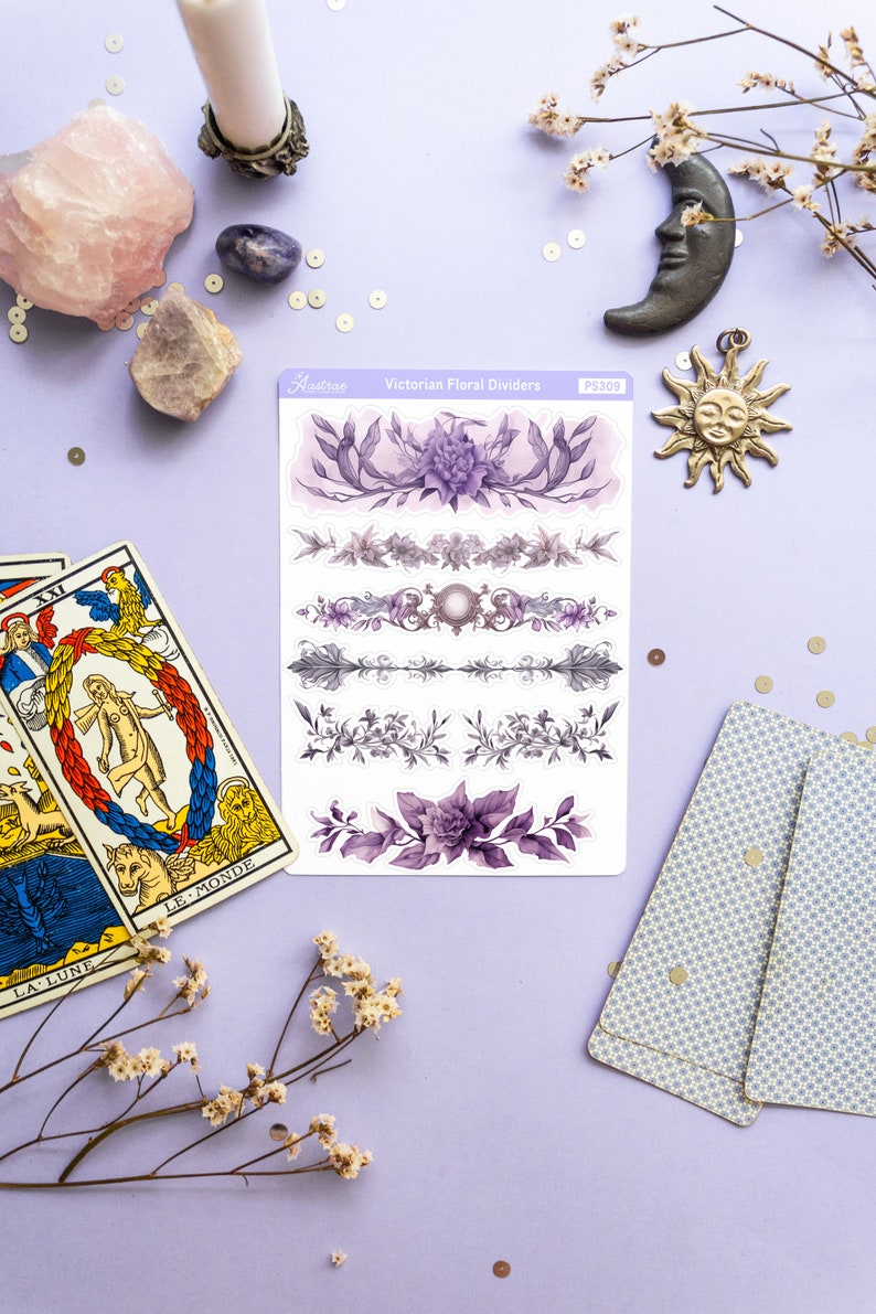Peut inclure: Une feuille d'autocollants de s&eacute;parateurs floraux victoriens avec des motifs floraux violets et gris. Les autocollants sont sur un fond violet clair avec un cristal rose, une bougie blanche et une lune argent&eacute;e.