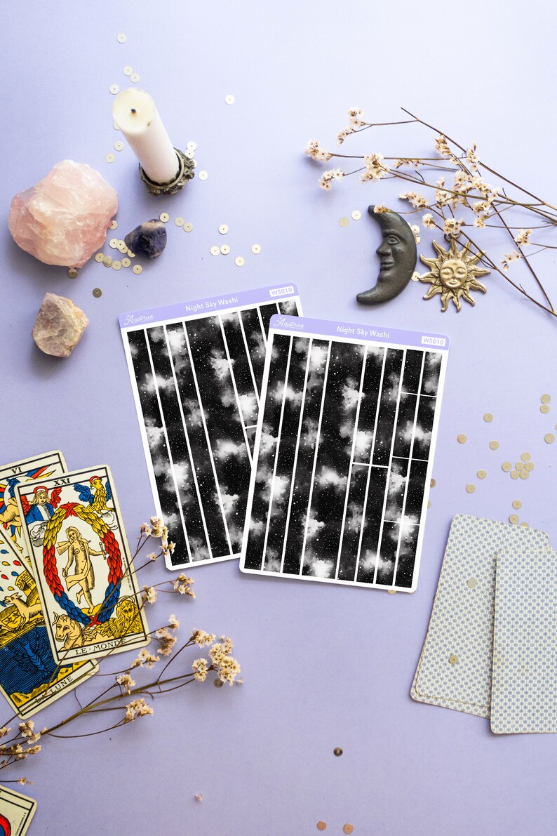 May include: Two sheets of black and white night sky washi tape with white stars and clouds. The washi tape is labeled "Night Sky Washi" and has the product number "WS018" and "WS019".