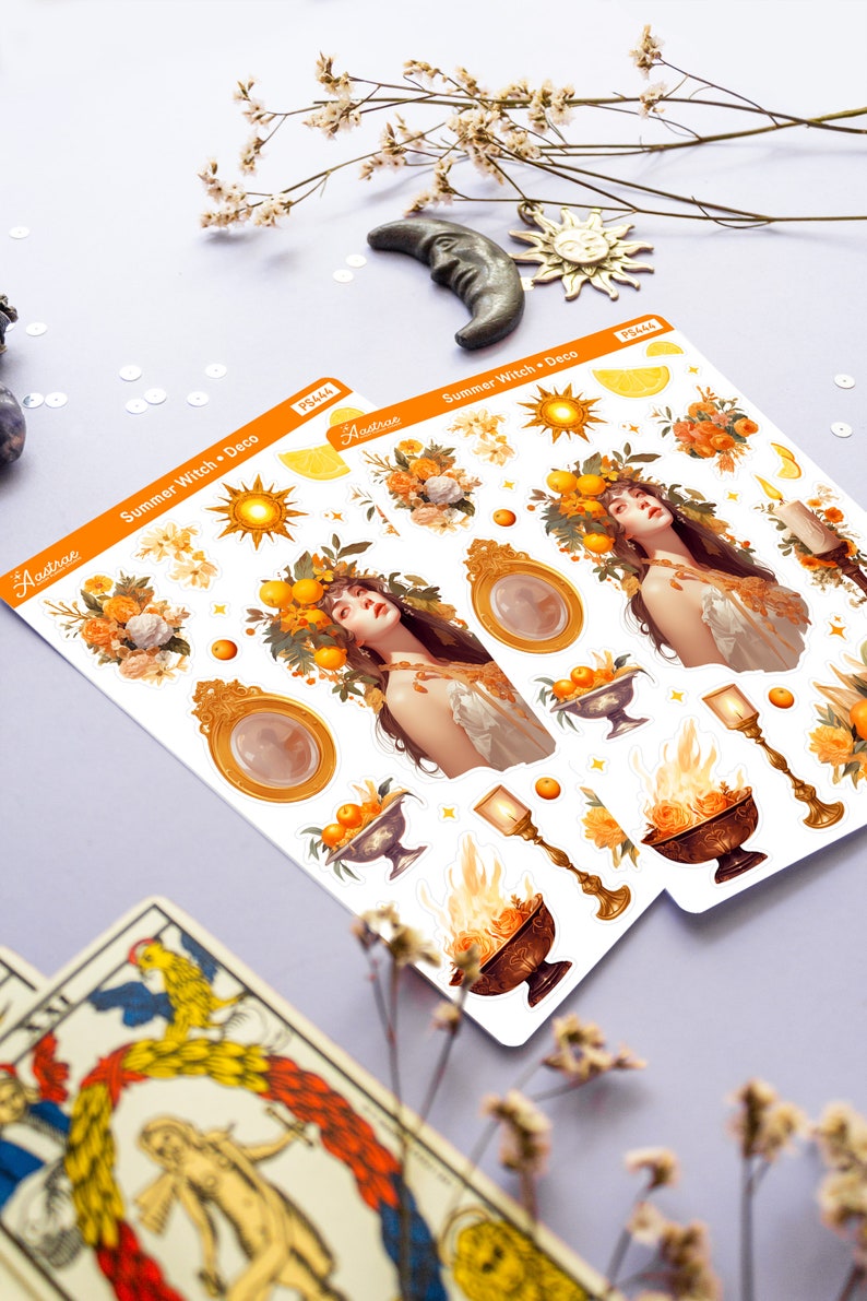 May include: A sheet of stickers featuring a summer witch theme. The stickers include a woman with a crown of lemons and oranges, a golden mirror, a sun, a candle, and a bowl of fruit. The stickers are on a white background with the text "Summer Witch Deco" and "Astrae" printed on the sheet.