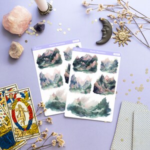 May include: Two sheets of stickers with a watercolor illustration of a mountain range with a lake in the foreground. The stickers are labeled "Mystic Mountains" and "PS371".